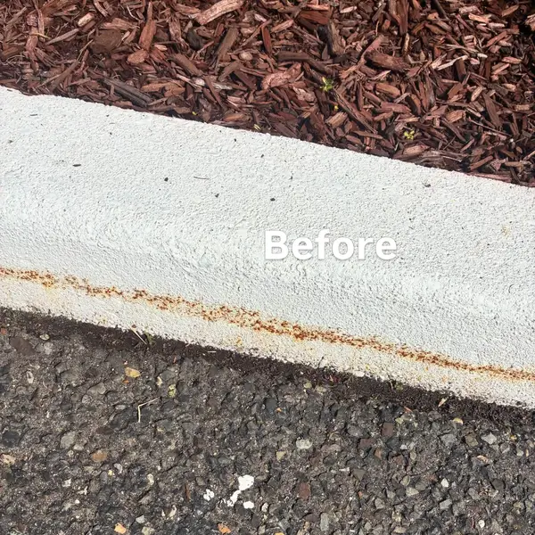 Before detail of rust staining and worn curb paint at a Berlin business