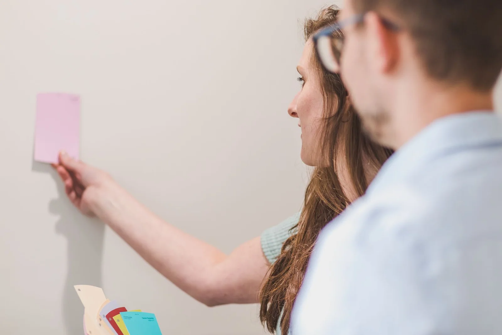 Homeowners comparing paint color swatches while planning an interior project